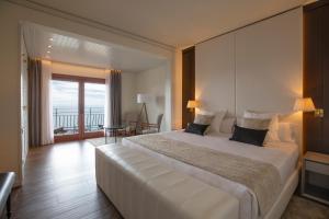 a bedroom with a large white bed with a balcony at Hotel Santa Marta in Lloret de Mar