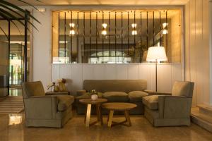 a living room with two chairs and a couch and a table at Hotel Santa Marta in Lloret de Mar