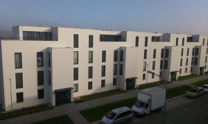 a large white building with cars parked in a parking lot at Alfa Panorama Brno in Brno