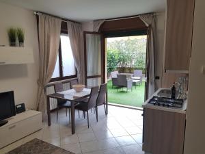 een keuken en eetkamer met een tafel en uitzicht op een tuin bij Appartamento Diamantina in Desenzano del Garda