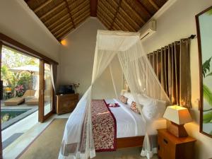 a bedroom with a bed with a mosquito net at Rumah Dadong in Ubud