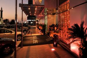 a sidewalk with cars parked in a parking lot at The Eclipse Boutique Suites in Abu Dhabi