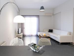 sala de estar con sofá blanco y sillas en City Center Apartment in Great Location, en Heraclión