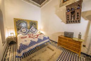 sypialnia z łóżkiem typu king-size i drewnianą komodą w obiekcie Charming Riad Ouliya in Fs with authentic Moroccan design w Fezie