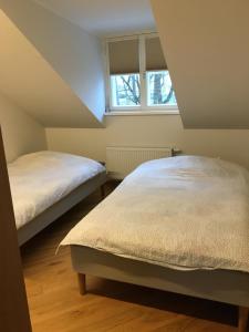 two beds in a attic bedroom with a window at Lossi 32 Penthouse in Tartu