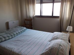 um quarto com uma cama e uma janela em Apartamento Fonte Luz em Matosinhos