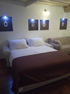 een slaapkamer met een groot bed en een bank bij Apartments Lufra Skradin in Skradin