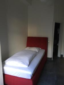 a bed in a room with a red and white mattress at Wasserturm Hotel Mannheim in Mannheim