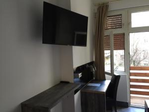 Zimmer mit einem Schreibtisch und einem TV an der Wand in der Unterkunft Wasserturm Hotel Mannheim in Mannheim