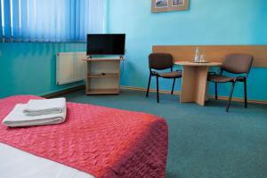Zimmer mit einem Bett, einem Tisch und einem TV in der Unterkunft Hotel Chemik in Bydgoszcz