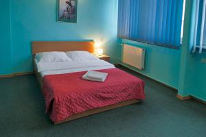 ein Schlafzimmer mit einem großen Bett mit einer roten Decke in der Unterkunft Hotel Chemik in Bydgoszcz