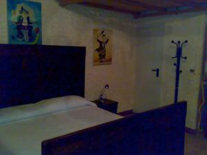 ein Schlafzimmer mit einem Bett und einem Kreuz an der Wand in der Unterkunft Ianua Coeli 2 in Mosso Santa Maria