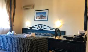 a bedroom with a bed and a table with towels at Villa Gaia Hotel in Cefalù +25 photos