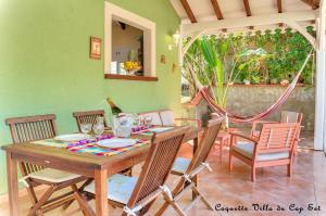 a dining room with a wooden table and chairs at Coquette villa du Cap Est in Le François