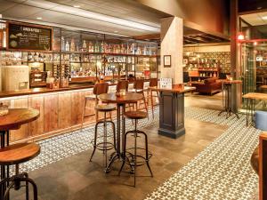 a bar with wooden floors and stools in a restaurant at ibis Manchester Centre 96 Portland Street in Manchester