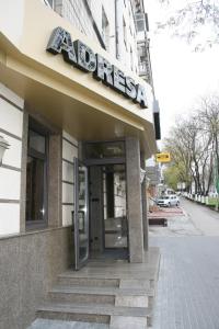 a building with a sign on the front of it at Hotel Apartments Adresa in Chişinău