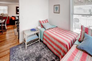比奇港Recently Renovated LBI Apt with Deck on Beach Block!的一间卧室，有两张床、一张桌子和一扇窗户