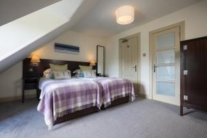 a bedroom with a large bed with a purple blanket at Nether Abbey Hotel in North Berwick