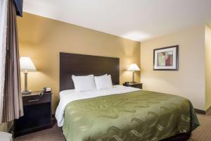 a hotel room with a large bed and two lamps at Quality Inn & Suites Menomonie in Menomonie