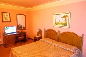 een slaapkamer met een bed en een bureau met een computer bij Villa La Nina in Montecarlo