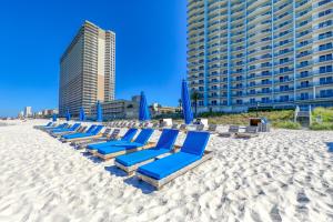 uma fila de espreguiçadeiras azuis na praia em Sterling Breeze 3 em Panama City Beach