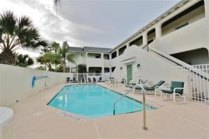 a swimming pool in front of a building at South Padre Island Condo with Pool Access and Balcony! in South Padre Island