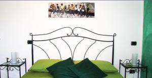 ein Schlafzimmer mit einem grünen Bett mit einem Kopfteil aus Metall in der Unterkunft Il borgo in Tavullia