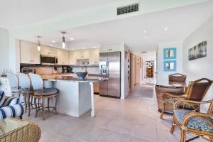 a kitchen with a counter and chairs in a room at Whitney Beach View 332 in Longboat Key