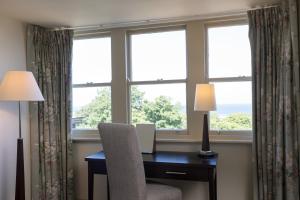 a room with a desk with a chair and windows at Nether Abbey Hotel in North Berwick