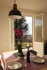 a table with a vase of flowers on it with a window at Agriturismo Badalone in Domaso