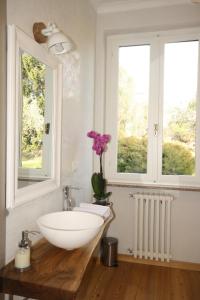 a bathroom with a white sink and two windows at Agriturismo Badalone in Domaso