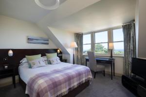 um quarto de hotel com uma cama, uma secretária e uma janela em Nether Abbey Hotel em North Berwick