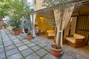 パレルモにあるDimora dei Leoni- Suiteの鉢植えの植物とテーブルと椅子が備わるパティオ