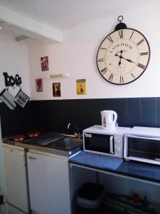 ティエールにあるAux vieilles ruellesのキッチン(壁掛け時計、電子レンジ付)