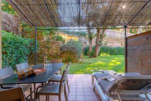 a patio with a table and chairs and a garden at La Résidence du Bailli in Rayol-Canadel-sur-Mer