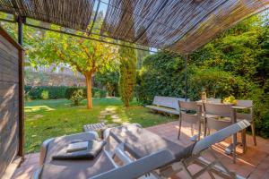 a patio with a table and chairs in a yard at La Résidence du Bailli in Rayol-Canadel-sur-Mer