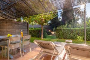 a patio with a table and chairs in a yard at La Résidence du Bailli in Rayol-Canadel-sur-Mer