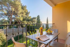 a table with a bowl of fruit on a balcony at La Résidence du Bailli in Rayol-Canadel-sur-Mer