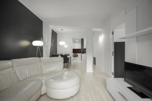 a living room with a white couch and a television at Picasso - Local Rentss in San Sebastián