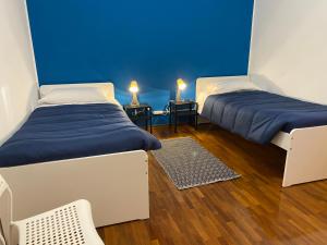 2 letti in una camera con pareti blu e pavimenti in legno di Campobasso 30E a Campobasso