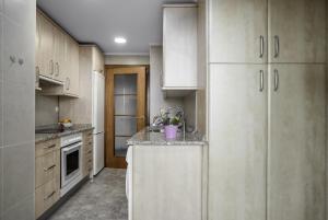 a kitchen with white cabinets and a counter top at Balea 2 - Local Rentss in Orio