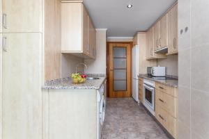 Una cocina con gabinetes de madera y encimera. en Balea 8 - Local Rentss, en Orio