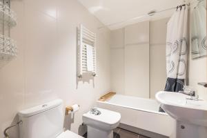 a white bathroom with a toilet and a sink at Balea 3 - Local Rentss in Orio