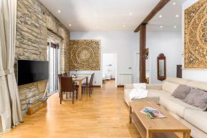 a living room with a couch and a stone wall at San Martin 2 - Local Rentss in San Sebastián