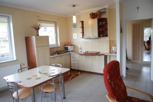 a kitchen with a table and chairs and a refrigerator at Apartament Bałtycka Plaża in Ustka