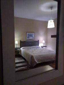 1 dormitorio con 1 cama, 2 lámparas y espejo en casa rural buenos aires, en Acebo