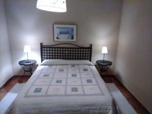 - une chambre avec un grand lit et deux lampes dans l'établissement casa rural buenos aires, à Acebo
