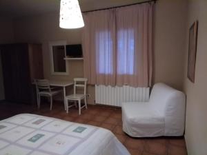 - une chambre avec un lit, une table et une chaise dans l'établissement casa rural buenos aires, à Acebo