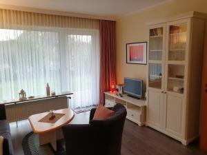 a living room with a television and a table and chairs at Haus Kersi in Büsum