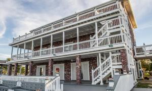 a large brick building with white balconies on it at Villa with Waterfront Deck 23 Mi to Bourbon Street! in Venetian Isles